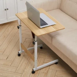 Over chair table with a laptop next to a beige sofa.