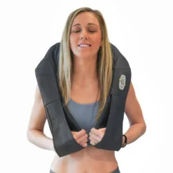 Woman wearing a neck and shoulder massager with control panel visible.