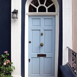 Blue front door with a black accessibility ramp at the threshold.