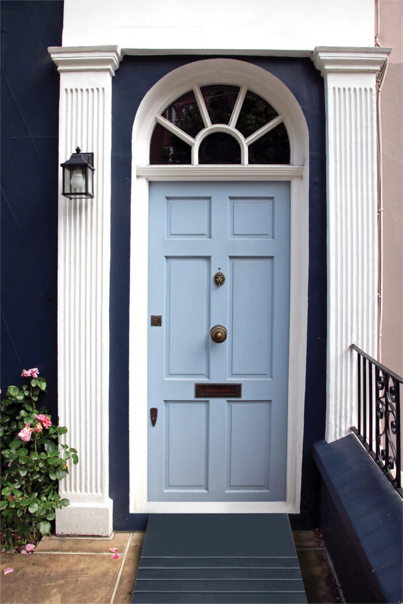 Blue front door with a black accessibility ramp at the threshold.