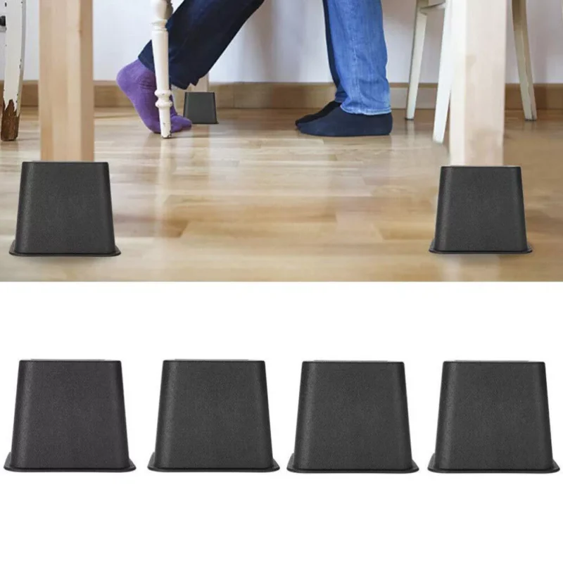 Black furniture raisers lifting a table, with a person sitting nearby.