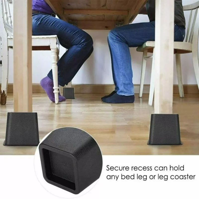Two chairs raised by black furniture raisers under a wooden table.