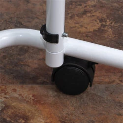 Close-up of an overbed table's castor wheel on a tiled floor.