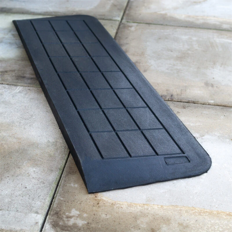 Black accessibility ramp placed on a stone surface.