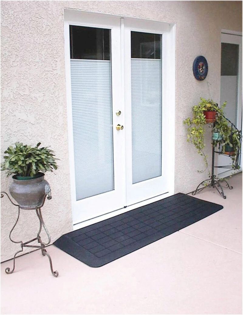 Black accessibility ramp at a white double door entrance.