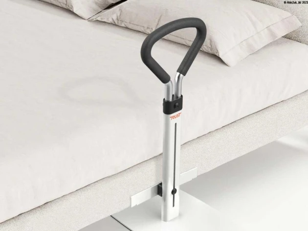 Bed support rail with a padded handle attached to a bed.
