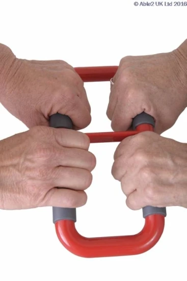 Two pairs of hands gripping a red ergonomic handle with gray non-slip grips.