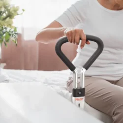 Person using a bed support rail with ergonomic grip.
