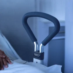 Bed support rail with ergonomic foam grip next to a bed.