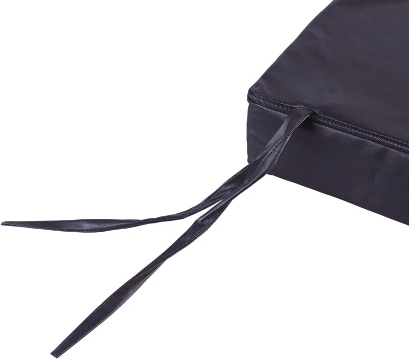 Close-up of a black wheelchair cushion with corner ties.