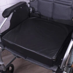 Black vinyl wheelchair cushion placed on a wheelchair seat.