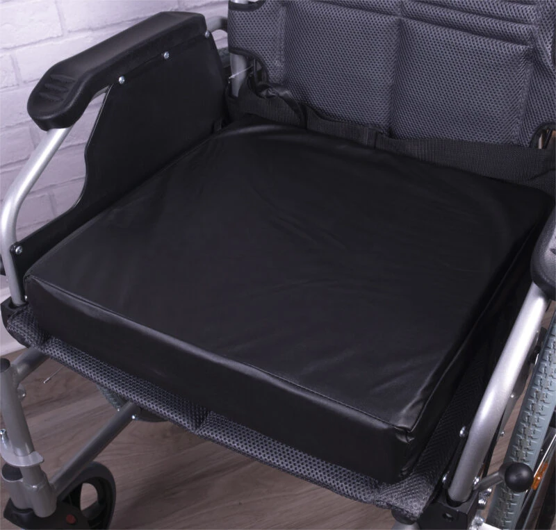Black vinyl wheelchair cushion placed on a wheelchair seat.