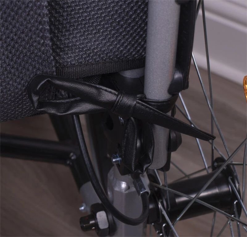 Close-up of a wheelchair cushion with black vinyl corner ties.