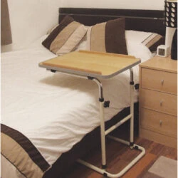Adjustable table over a bed with a beech-effect surface.