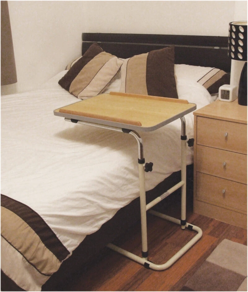 Adjustable table over a bed with a beech-effect surface.