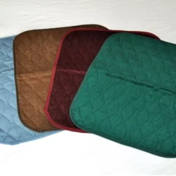 Four incontinence chair pads in blue, brown, burgundy, and green.