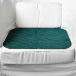 Green incontinence chair pad placed on a white chair.