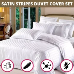 White satin striped duvet cover set on a bed with multiple pillows.