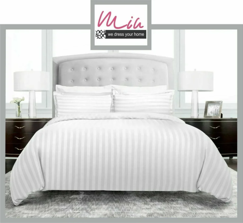 White striped duvet cover on a bed with pillows and bedside tables.