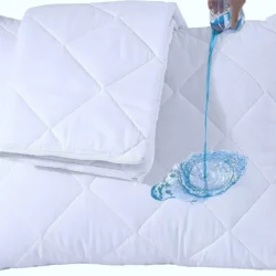 Water being poured on a quilted pillow protector demonstrating waterproof feature.