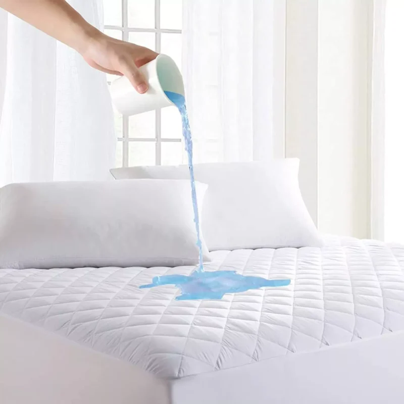 Water being poured onto a quilted mattress protector to show waterproof feature.