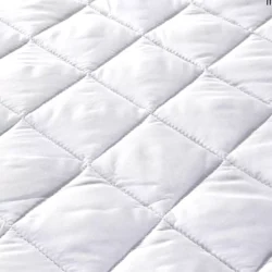 Close-up of a quilted white mattress protector.