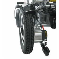 Close-up of rear wheel and motor of a folding electric wheelchair.