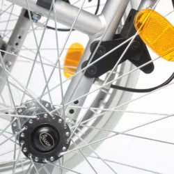 Close-up of a wheelchair's rear wheel with spokes and reflectors.
