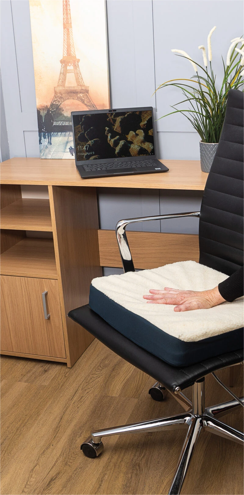 Gel seat cushion on a black office chair with a hand pressing it.