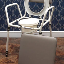 Height adjustable commode chair with detachable padded seat.