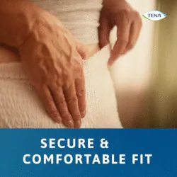 Close-up of person wearing Tena Pants Bariatric with hands adjusting the waistband.