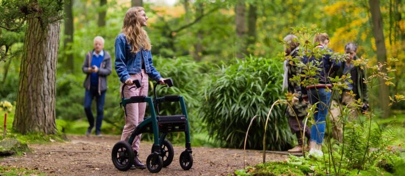 Person using Rollz Motion Performance walker on a forest path.
