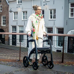 Person using Rollz Motion Rhythm Rollator on a city street.
