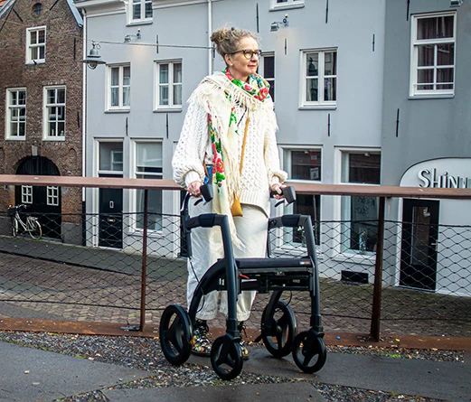 Person using Rollz Motion Rhythm Rollator on a city street.