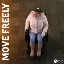 Person in a white coat using an electric wheelchair on a tiled surface.