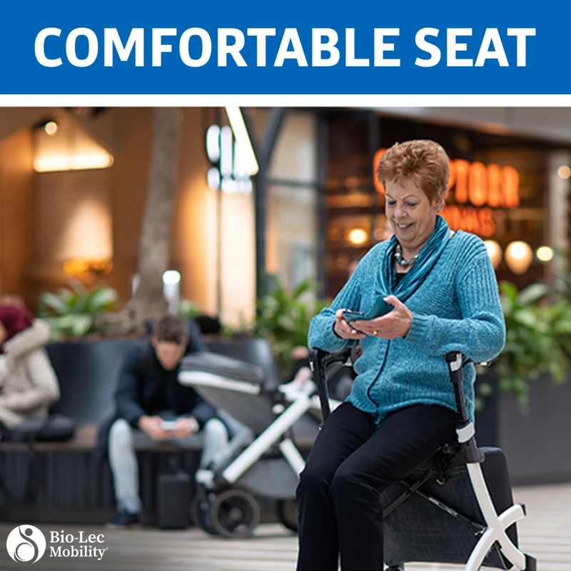 Person sitting on a Rollz Flex Shopper rollator in a shopping area.