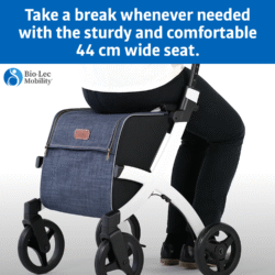 Person sitting on the Rollz Flex Shopper rollator with a blue shopping bag.