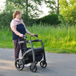 Person using the Rollz Motion Rhythm Rollator on a paved path.