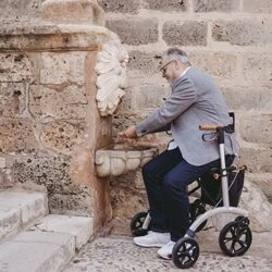 Man with Saljol Allround Crossover Rollator at a stone fountain