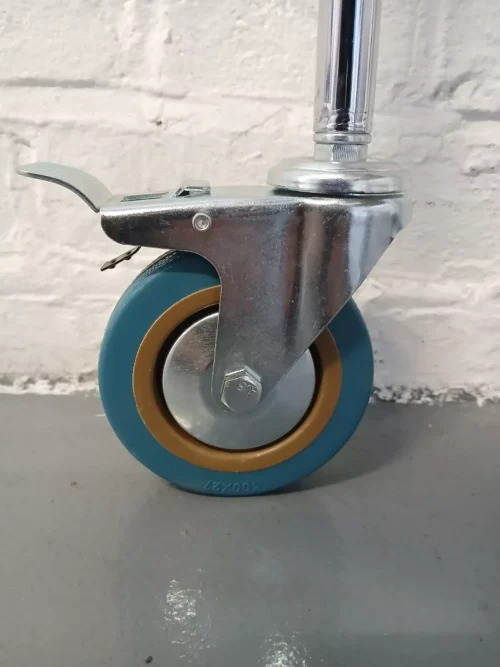 Close-up of a blue caster wheel with a metal bracket on a trolley.