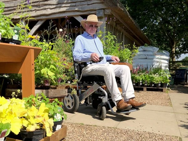 Person using the Freedom Chair A06L electric wheelchair outdoors.