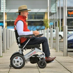 Person using Freedom Chair A06L electric wheelchair outdoors.