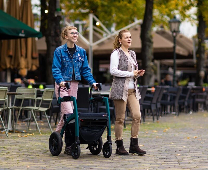 Two people outdoors, one using the Rollz Motion Performance walker.