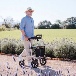 Man walking with Saljol Allround Crossover Rollator on a gravel path.