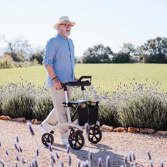Man walking with Saljol Allround Crossover Rollator on a gravel path.