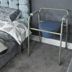 Bedside commode with adjustable legs next to a bed.