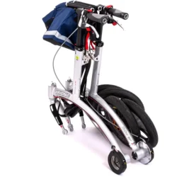 Folded Trionic Walker Rollator with blue bag and visible wheels.