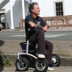 Person seated on a Trionic Walker Rollator outdoors.