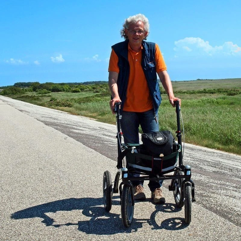 Person using Trionic 14er Rollator Walker on an outdoor path.