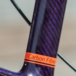 Close-up of a carbon fibre frame with a label reading 'Carbon Fibre'.